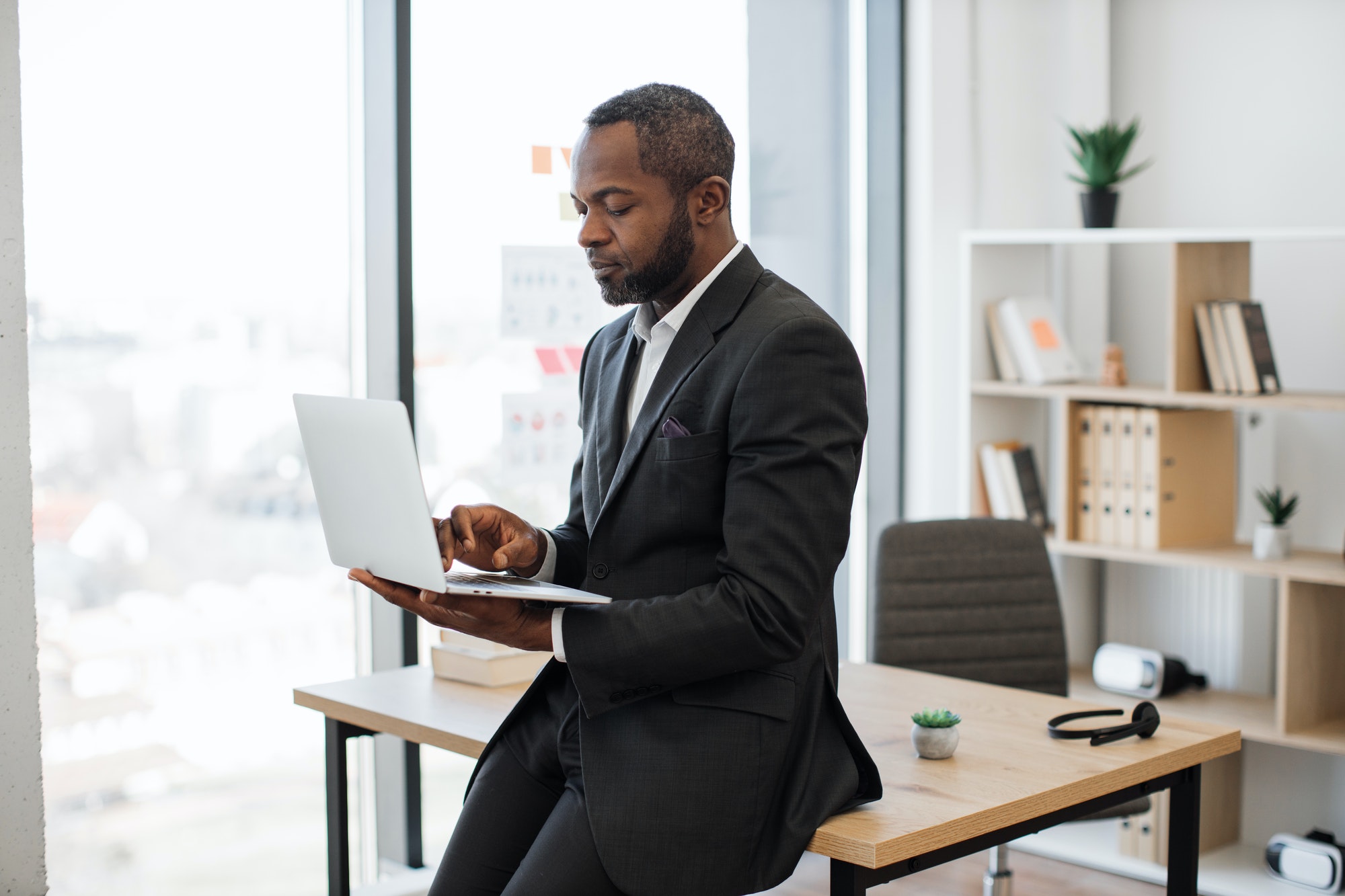 Male employer checking emails on modern laptop at work