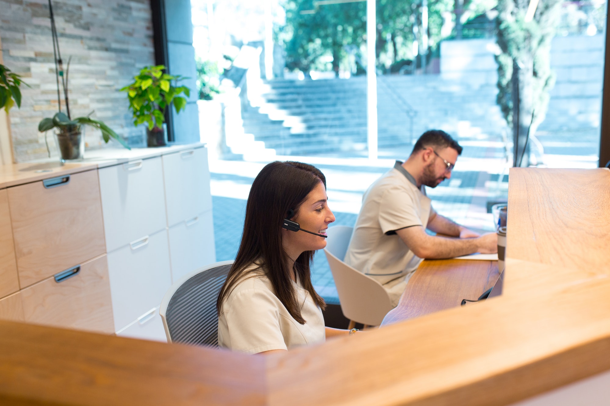 Two receptionists working at the front desk of a physiotherapy health center